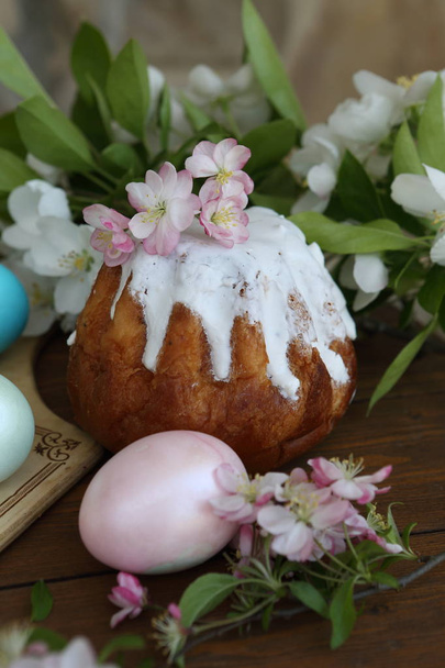 Painted eggs and easter cake on a wooden table - Фото, изображение