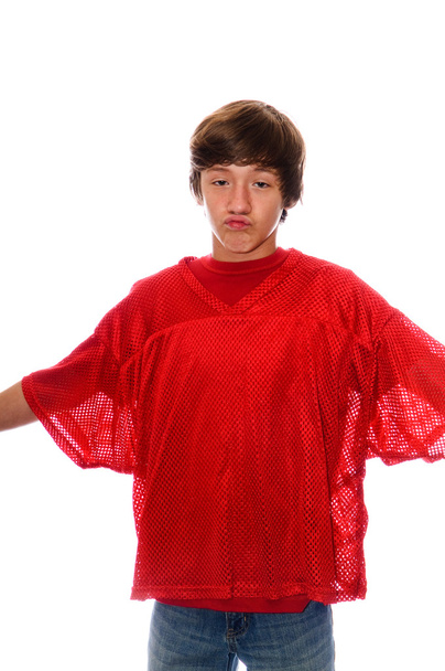 Jugendlicher Junge im roten Trikot isoliert auf weißem Grund - Foto, Bild