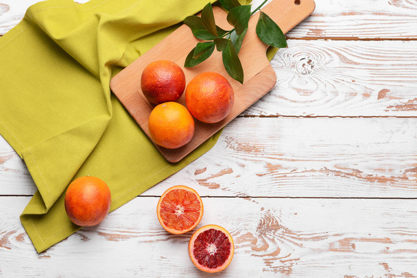 Cutting board with fresh blood oranges on white table - Photo, Image
