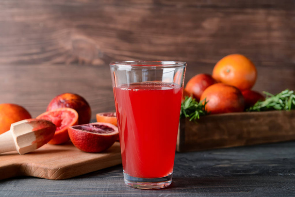 Vaso de jugo de naranja de sangre fresca sobre mesa de madera
 - Foto, imagen