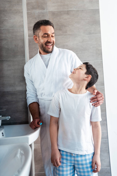 happy father hugging son in bathroom during morning routine - 写真・画像