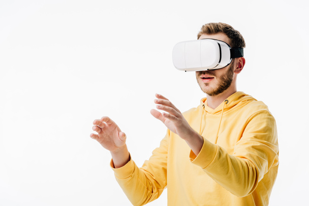 young man in yellow hoodie using virtual reality headset isolated on white - Foto, immagini