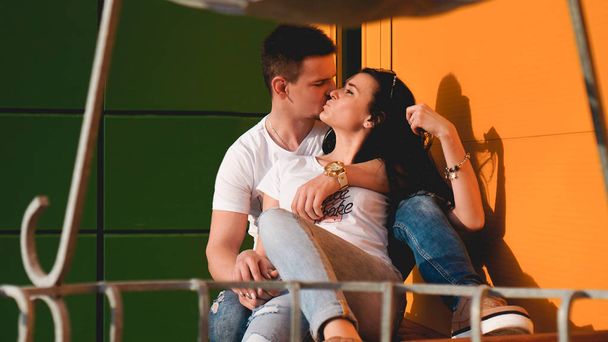 Couple kissing against isolated yellow and green wall in the city - Foto, imagen
