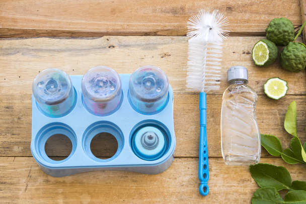arka plan ahşap üzerinde bebeğin süt şişe sağlık temizlik için bitkisel sıvı yıkama  - Fotoğraf, Görsel