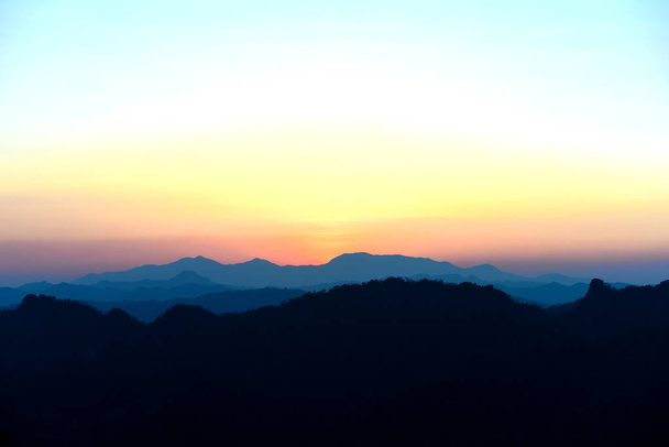 kilátás ködös hegyvidéki táj naplementekor - Fotó, kép