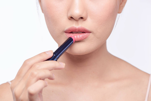 Jolie asiatique femme appliquant rouge à lèvres, isolé sur blanc
 - Photo, image