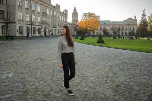 Kaunis tyttö kävelee lähellä yliopiston kampuksen
 - Valokuva, kuva