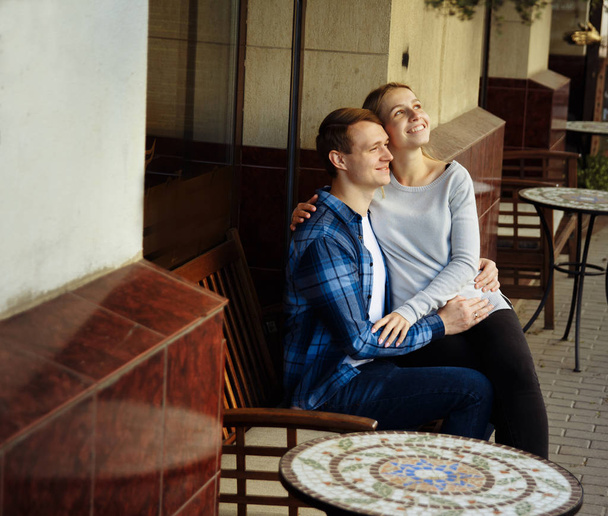 mutlu çift masada dışarıda oturuyor. bir adamın kollarında kız. Sokak Kafe - Fotoğraf, Görsel