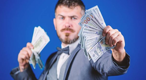 A profitable business. Bearded man holding cash money. Making money with his own business. Currency broker with bundle of money. Rich businessman with us dollars banknotes. Business startup loan - 写真・画像