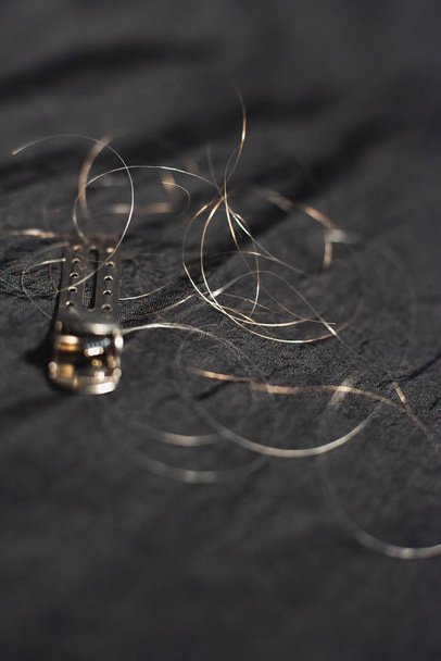 Κλιπ μαλλιών με χαλαρά μαλλιά που βρίσκονται σε μαύρο ύφασμα. - Φωτογραφία, εικόνα