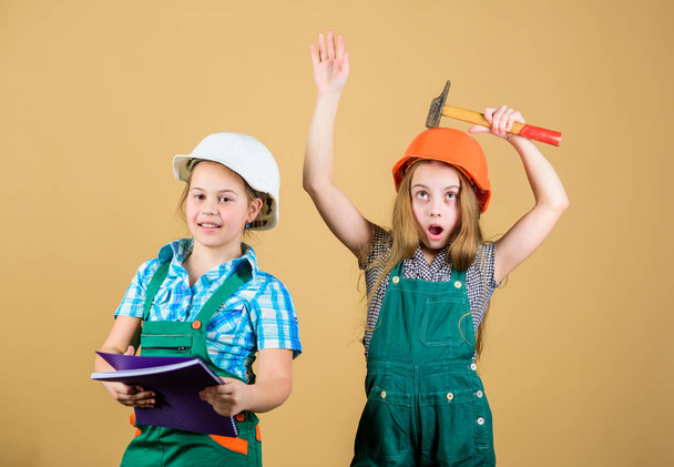 Little kids in helmet with tablet and hammer. Labor day. 1 may. small girls repairing together in workshop. Foreman small girls inspector. Repair. happy children. Future career. small girls - Foto, Imagen