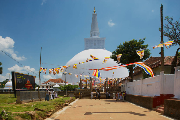 Anuradhapura, Sri Lanka - May 19, 2011: People visit Ruwanwelisaya stupa in Anuradhapura, Sri Lanka. Ruwanwelisaya is a sacred place for Buddhists and one of the largest stupas in the world.  - Foto, imagen