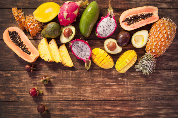 Tropical fruits, papaya, Dragon Fruit, rambutan, tamarind, avocado, granadilla, carambola kumquat mango mangosteen passionfruit On a wooden background. Assorted - Fotó, kép