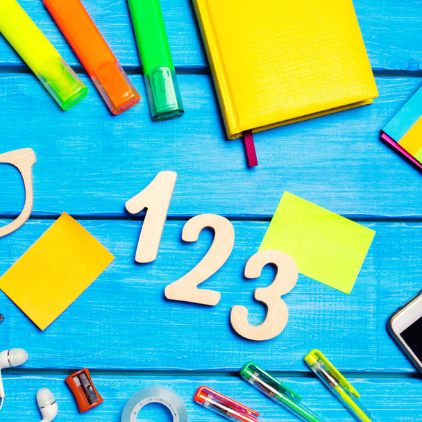 school supplies in the school desk, stationery, school concept, blue background, creative chaos, space for text, markers, pens, notepads, stickers. wooden numbers 1, 2, 3 - Foto, Imagen
