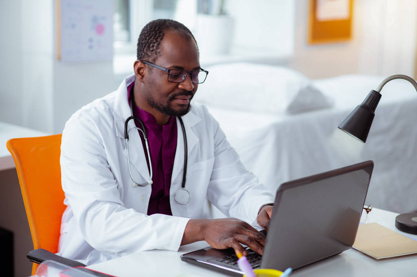 Bearded dark-skinned medical scientist working on laptop - Zdjęcie, obraz