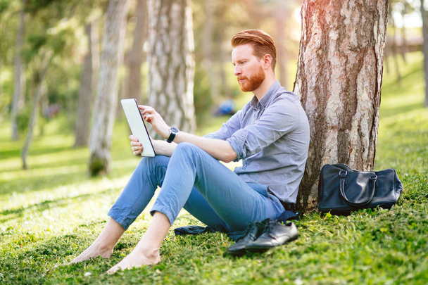 Handsome student reading and studying in park - Φωτογραφία, εικόνα