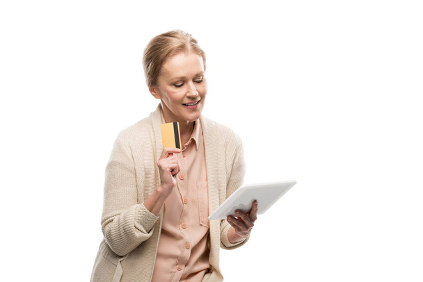 sorridente donna di mezza età con carta di credito utilizzando Digital Tablet isolato su bianco
 - Foto, immagini