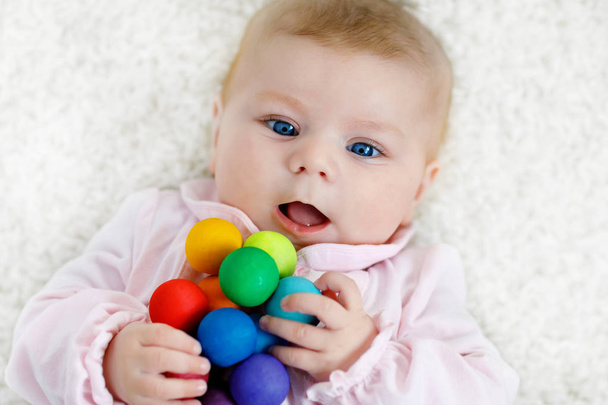 Linda niña jugando con colorido juguete sonajero de madera
 - Foto, Imagen