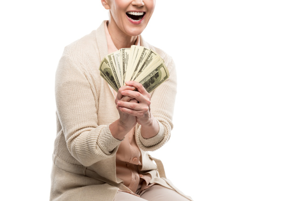 ドル紙幣を白に孤立させた幸せな中年女性のトリミングされたビュー - 写真・画像