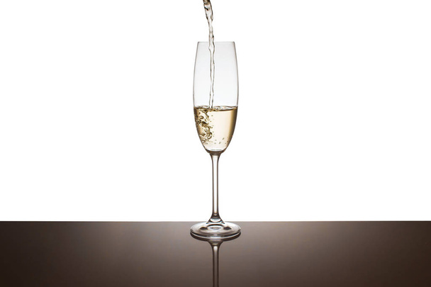 Шампанське наливають в окуляри на білому тлі
 - Фото, зображення