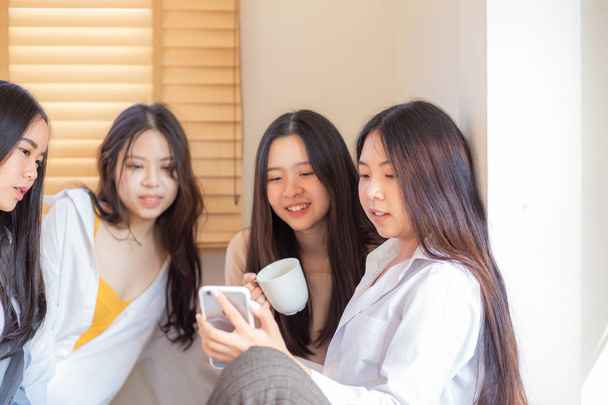 ベッドの上でかなり若いアジアの女性の友人のグループ - 写真・画像