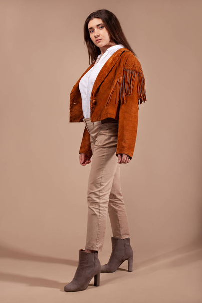 Woman wearing fashion clothes on brown background. - Φωτογραφία, εικόνα