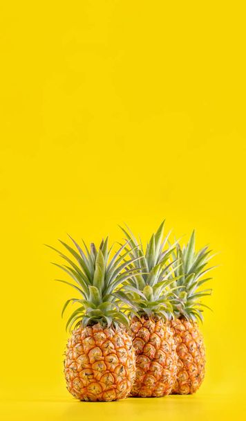 Beautiful fresh pineapple isolated on bright yellow background, summer seasonal fruit design idea pattern concept, copy space, close up - Zdjęcie, obraz