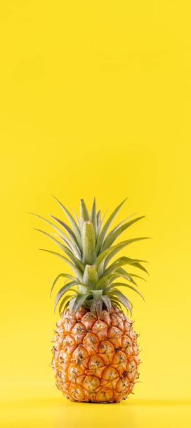 Beautiful fresh pineapple isolated on bright yellow background, summer seasonal fruit design idea pattern concept, copy space, close up - Photo, image