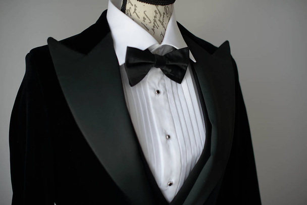 Plan recadré d'élégant costume cravate noire avec chemise blanche et noeud papillon en soie sur le torse mannequin ou une forme de robe, accessoires de sartorial pour tenue formelle, marié chic ou un homme d'affaires sophistiqué
 - Photo, image
