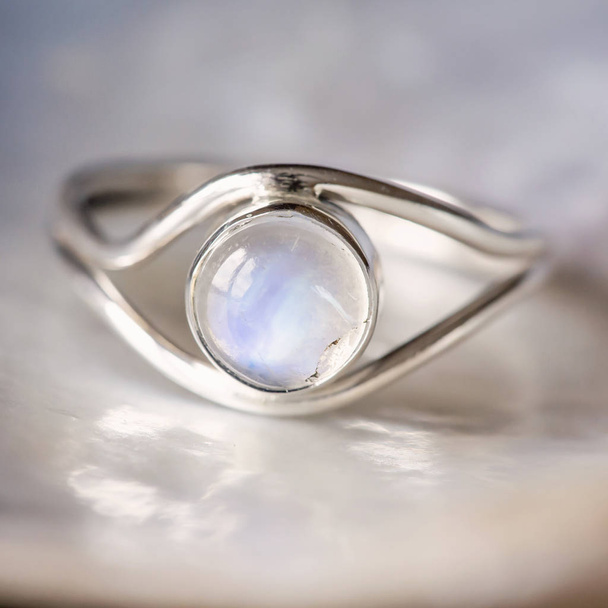 Elegante vrouwelijke zilveren ring op natuurlijke shell parelmoer achtergrond - Foto, afbeelding