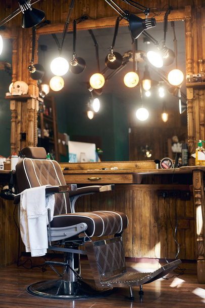 Empty barber chair in wooden interior - Zdjęcie, obraz