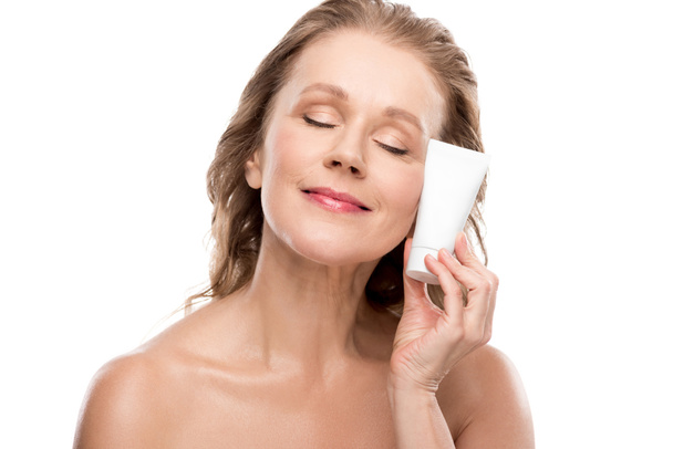 attractive mature woman with perfect skin holding moisturizing Face cream Isolated On White - Valokuva, kuva