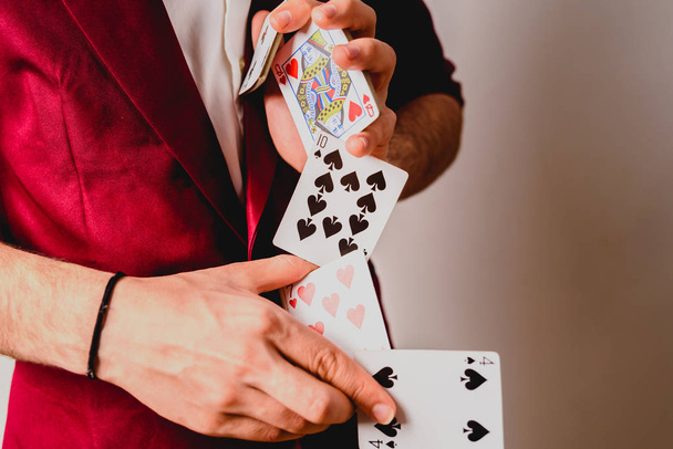Young magician juggling a deck of playing cards. - Foto, Bild