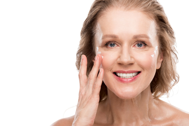 mature femme appliquant la crème cosmétique sur le visage isolé sur blanc
 - Photo, image