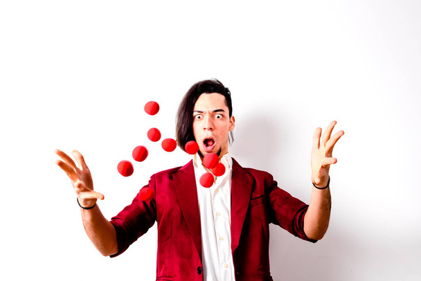 Young magician throwing red air balls to look for luck. - Foto, Imagen