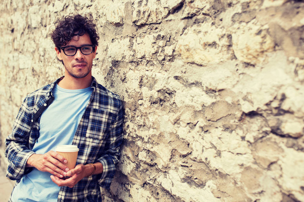 man in eyeglasses drinking coffee over street wall - Φωτογραφία, εικόνα