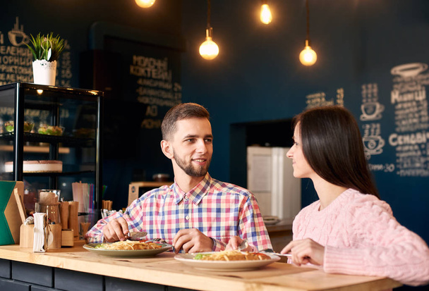 giovane coppia seduta godendo appetitoso pranzo cibo e bevande in ristorante atmosferico
 - Foto, immagini