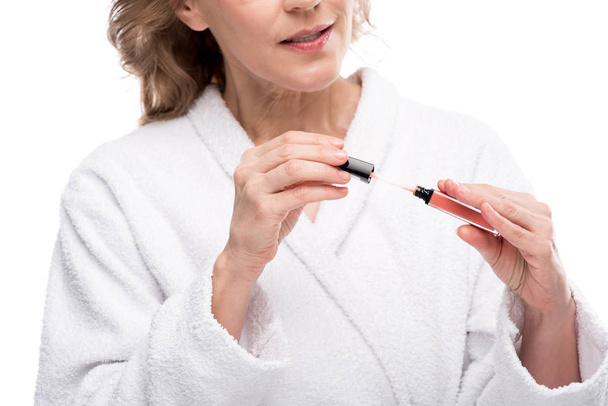 Cropped view of mature woman holding lip gloss Isolated On White  - Zdjęcie, obraz