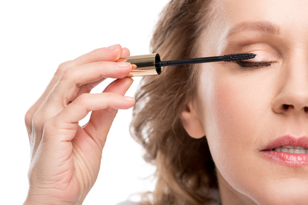 cropped view of mature woman applying mascara Isolated On White - Zdjęcie, obraz
