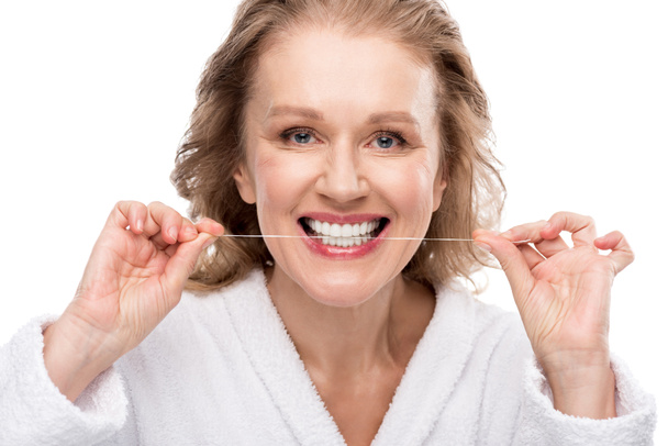 žena středního věku používající zubní nit izolovaný na bílém - Fotografie, Obrázek