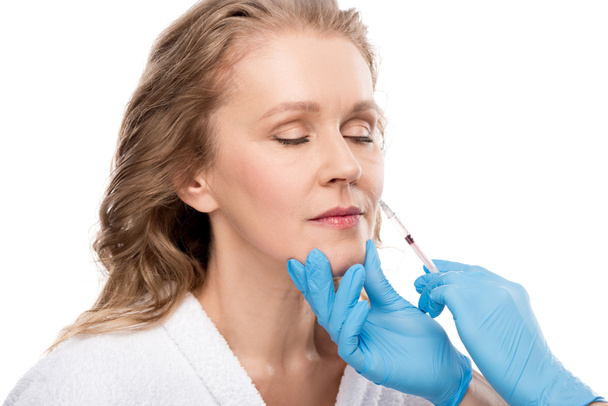 doctor giving beauty injection to middle aged woman Isolated On White - 写真・画像