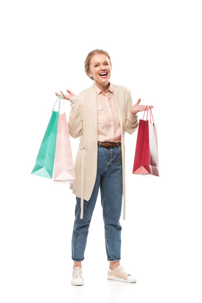 sonriente mujer de mediana edad con bolsas de compras aisladas en blanco
 - Foto, imagen
