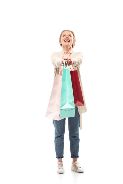 ευτυχισμένος μεσήλικες γυναίκα με σακούλες για ψώνια σε λευκό - Φωτογραφία, εικόνα