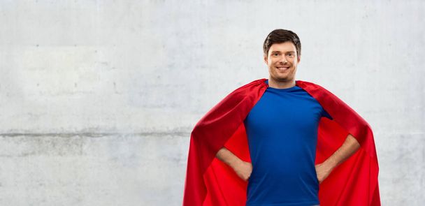 man in red superhero cape over concrete background - Foto, Bild