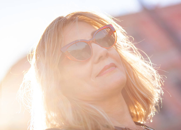 Portret van een vrouw met rode zonnebril. - Foto, afbeelding