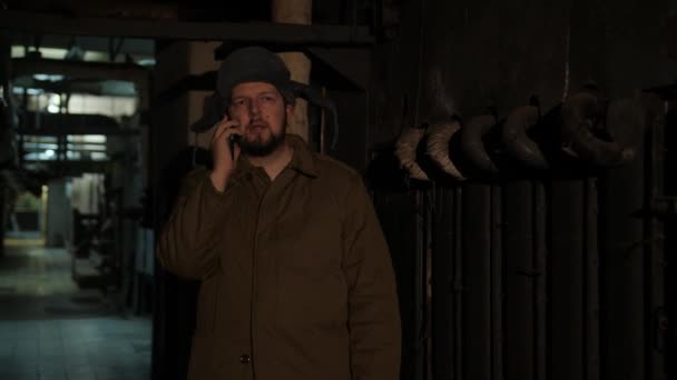 Homem russo de chapéu com abas auriculares, falando ao telefone em um porão escuro e decide assuntos de importância nacional
. - Filmagem, Vídeo