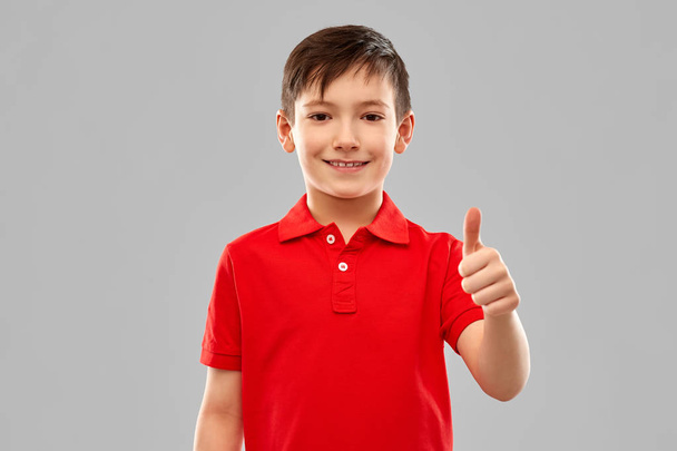 smiling boy in red t-shirt showing thumbs up - Foto, immagini