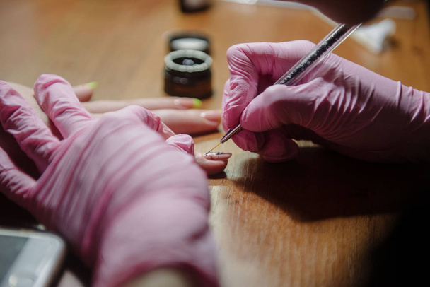 Manicurist applies varnish on the nail close up - Photo, Image