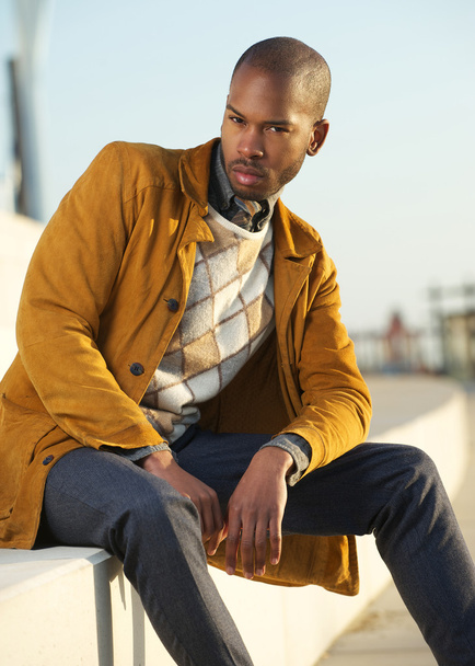 Handsome male fashion model sitting outdoors - Foto, Imagen