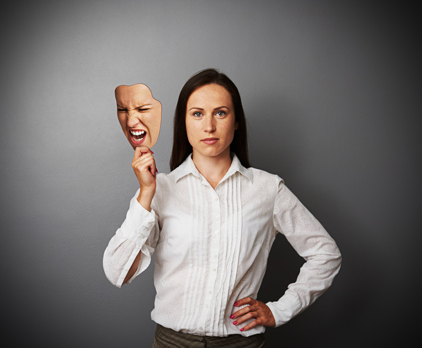 quiet woman holding aggressive mask - Photo, image